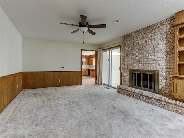 7000 N Libby Ave, Oklahoma City, OK 73132 - unfurnished living room featuring a brick fireplace, light carpet, ceiling fan, and wood walls