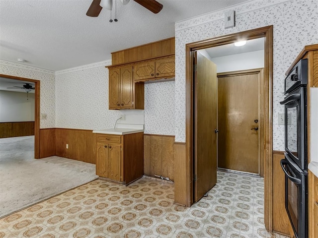 7000 N Libby Ave, Oklahoma City, OK 73132 - kitchen featuring black double oven, ceiling fan, a textured ceiling, and wood walls