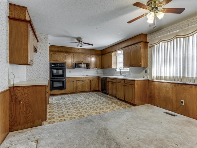7000 N Libby Ave, Oklahoma City, OK 73132 - kitchen featuring wood walls, sink, ceiling fan, black appliances, and a textured ceiling