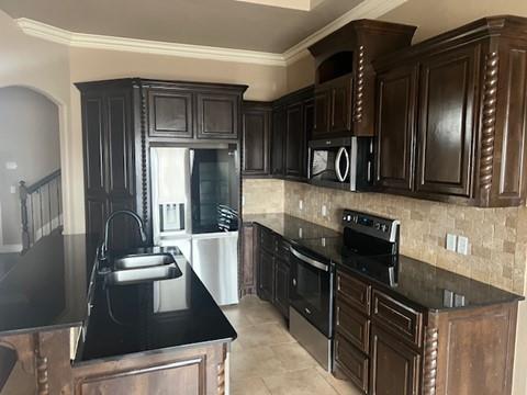 kitchen with ornamental molding, sink, stainless steel appliances, and tasteful backsplash