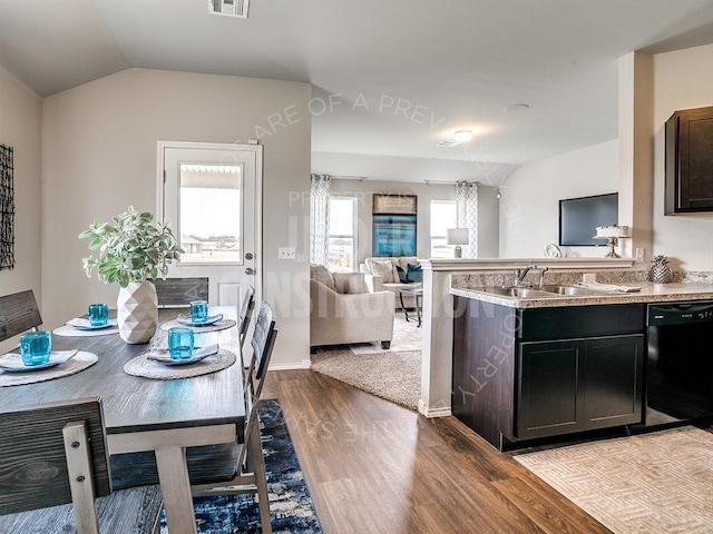 kitchen featuring vaulted ceiling, black dishwasher, sink, dark brown cabinets, and light hardwood / wood-style flooring