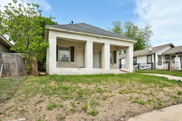 1315 NW 7th St, Oklahoma City, OK 73106 - view of front of house featuring fence, roof with shingles, and brick siding