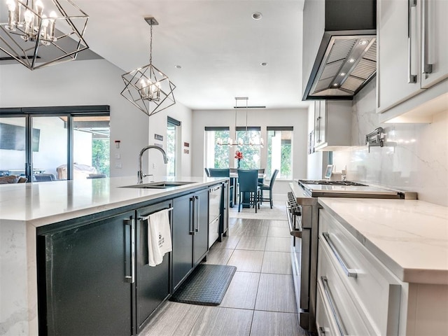 kitchen with sink, white cabinetry, appliances with stainless steel finishes, an island with sink, and pendant lighting