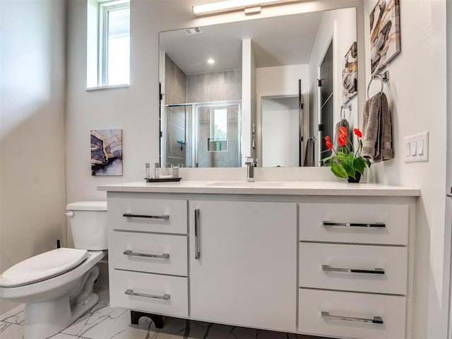 bathroom featuring vanity, a shower with door, and toilet