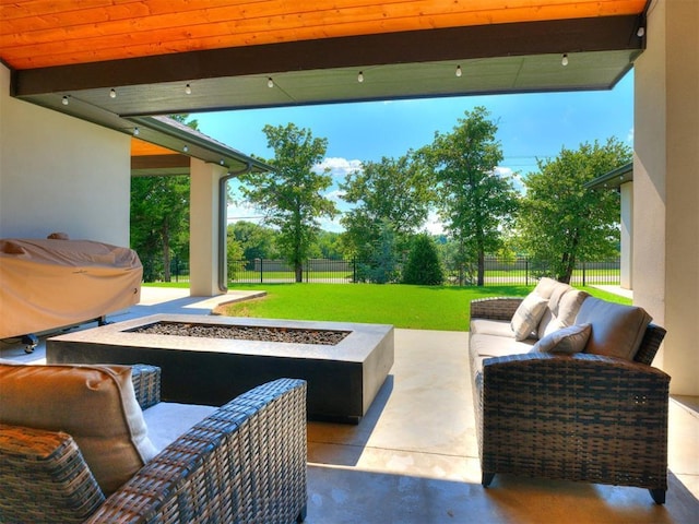 view of patio with a grill and an outdoor living space with a fire pit