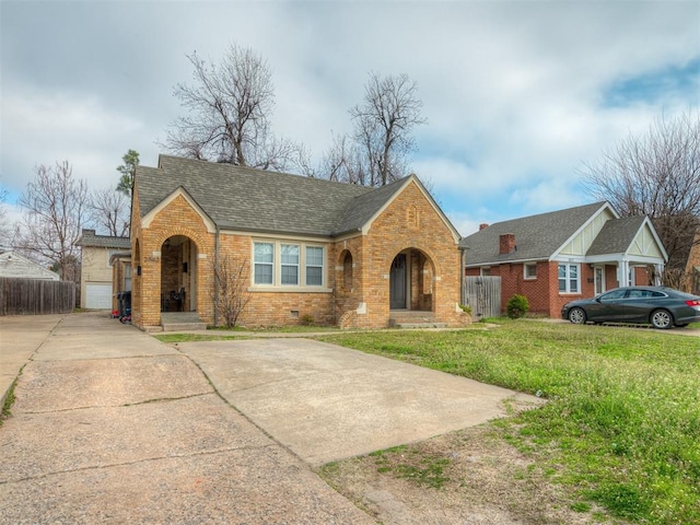 view of front facade featuring brick siding, a shingled roof, fence, a front yard, and crawl space