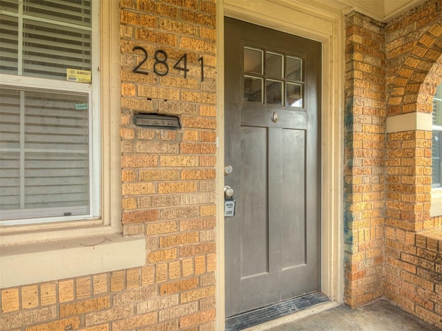 property entrance featuring brick siding