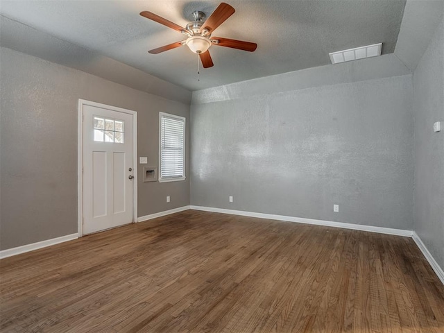 entryway with wood finished floors, visible vents, baseboards, ceiling fan, and a textured ceiling