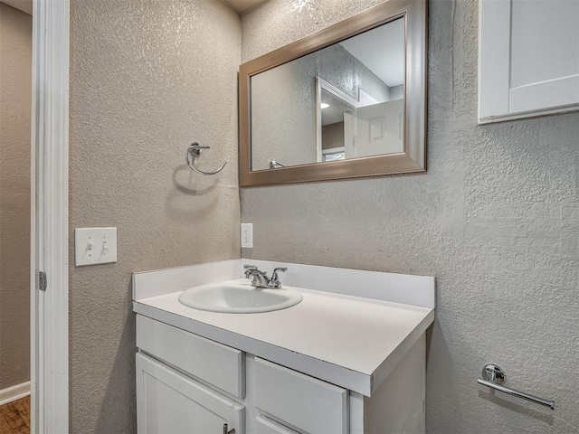 bathroom featuring vanity and a textured wall