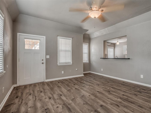 entrance foyer featuring a ceiling fan, lofted ceiling, wood finished floors, and baseboards