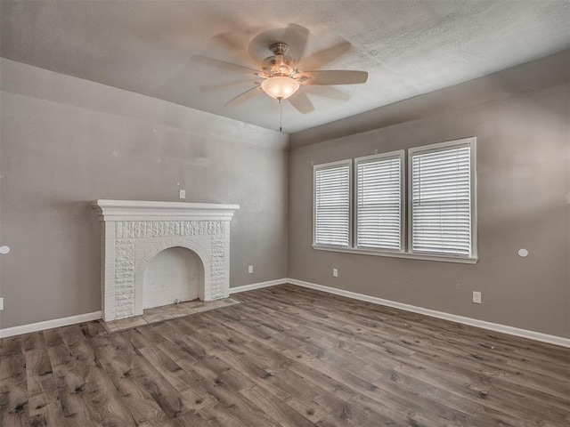 unfurnished living room featuring a ceiling fan, wood finished floors, and baseboards