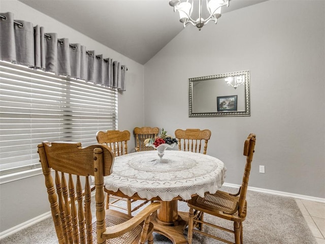 dining room featuring lofted ceiling, baseboards, a notable chandelier, and tile patterned floors