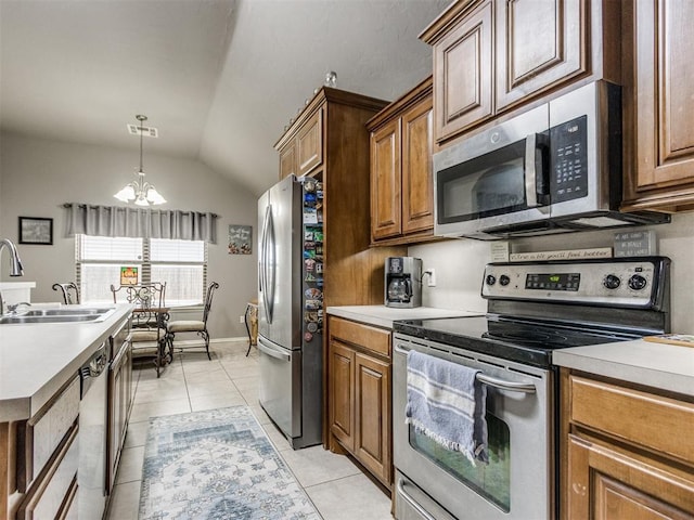 kitchen featuring light countertops, appliances with stainless steel finishes, brown cabinetry, and a sink