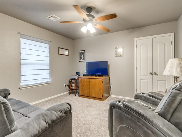 carpeted living room featuring a ceiling fan, visible vents, and baseboards