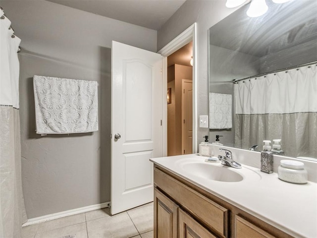 bathroom with tile patterned flooring, vanity, and baseboards