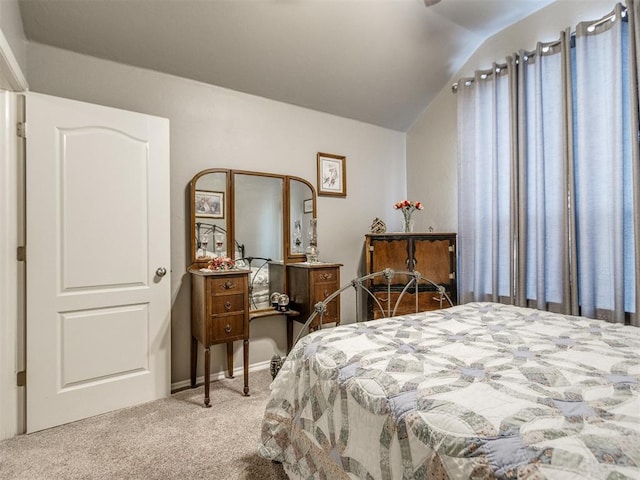 bedroom featuring vaulted ceiling and light colored carpet