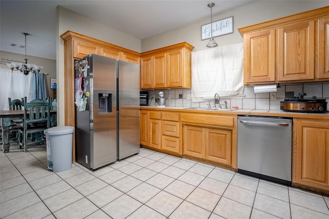 kitchen featuring hanging light fixtures, decorative backsplash, stainless steel appliances, and sink