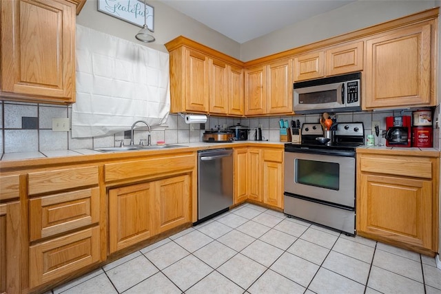 kitchen featuring sink, backsplash, stainless steel appliances, and light tile patterned floors