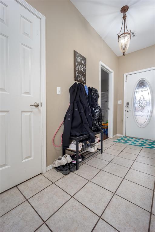 entrance foyer featuring light tile patterned floors and a notable chandelier