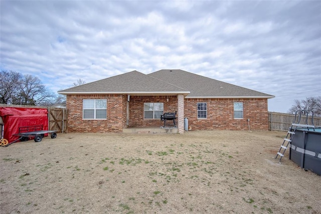 rear view of house featuring a fenced in pool