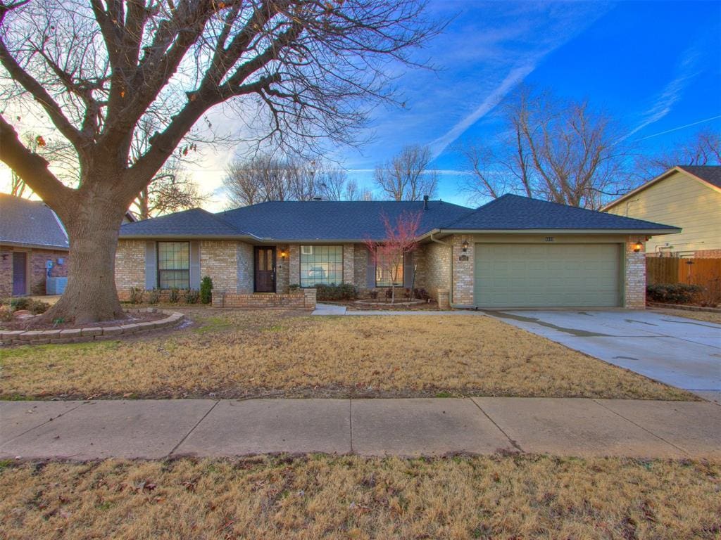 ranch-style home with a garage and a lawn