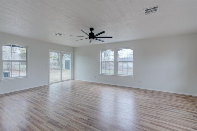 unfurnished room featuring ceiling fan, light hardwood / wood-style floors, and a textured ceiling