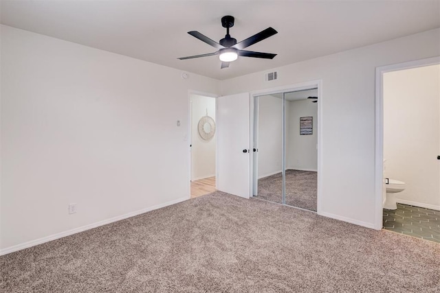 unfurnished bedroom featuring connected bathroom, a closet, ceiling fan, and carpet flooring