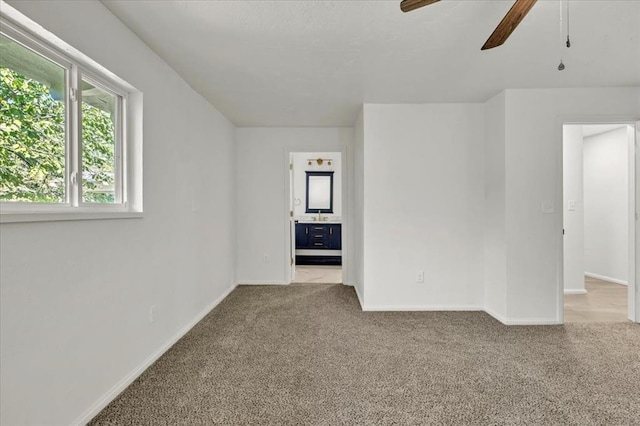 unfurnished room with ceiling fan and light carpet