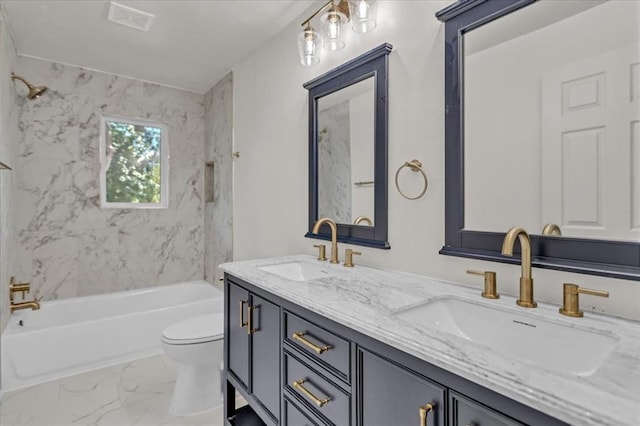 full bathroom featuring tiled shower / bath, vanity, and toilet