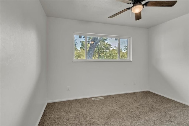 carpeted spare room featuring ceiling fan