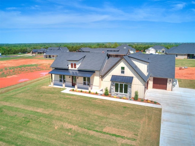 modern farmhouse style home featuring a porch, a front lawn, board and batten siding, and concrete driveway