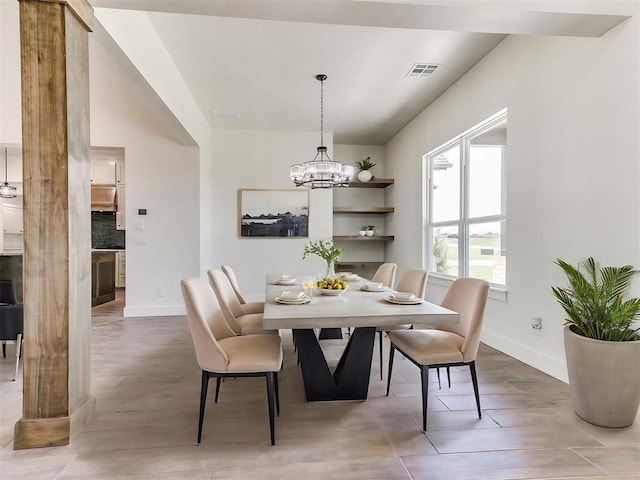 dining area with a notable chandelier, visible vents, baseboards, and wood finished floors