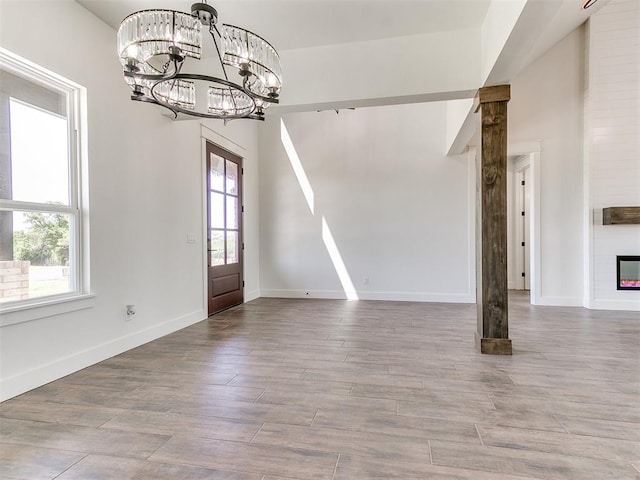 unfurnished dining area with baseboards, a notable chandelier, and plenty of natural light