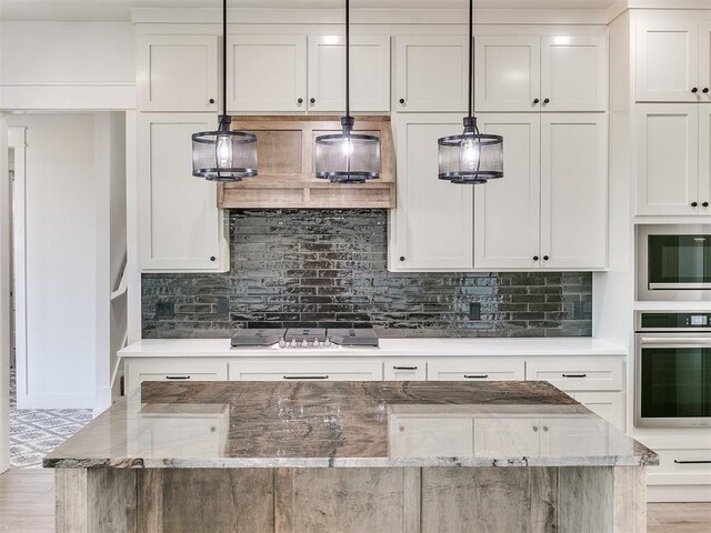 kitchen with light stone counters, white cabinets, tasteful backsplash, and stainless steel appliances