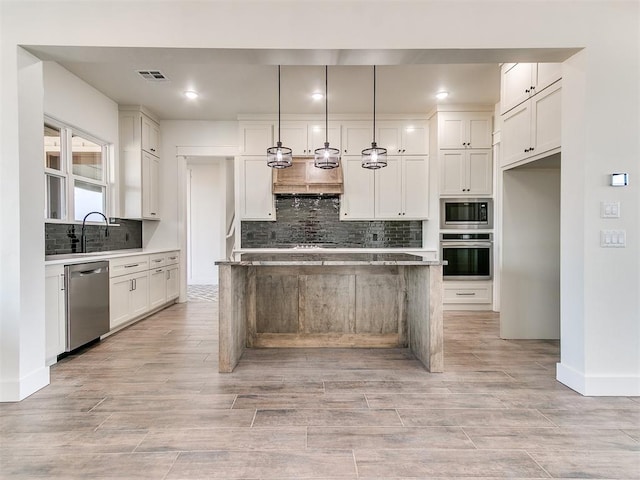 kitchen with appliances with stainless steel finishes, decorative backsplash, and white cabinets