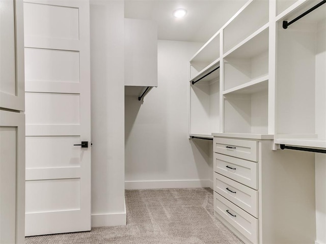 walk in closet with light colored carpet