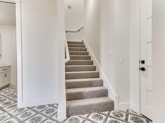 stairs with baseboards and visible vents