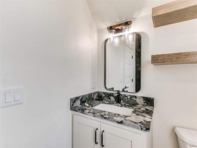 half bathroom with vanity and toilet