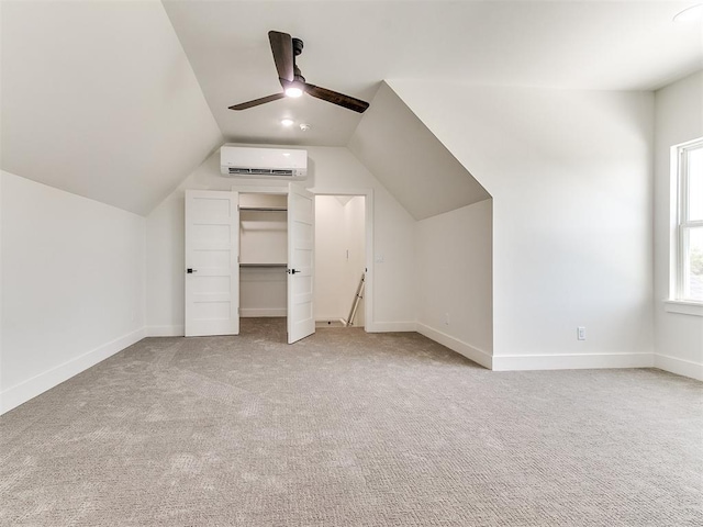 bonus room with carpet floors, a ceiling fan, baseboards, a wall unit AC, and vaulted ceiling