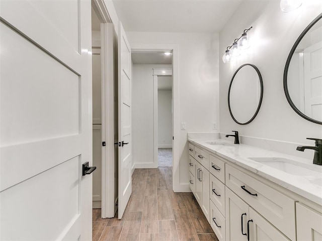 bathroom featuring double vanity, a sink, and wood finished floors