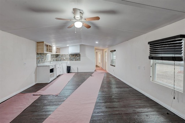 unfurnished living room featuring lofted ceiling, dark hardwood / wood-style floors, a wealth of natural light, and ceiling fan