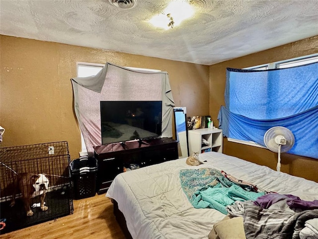 bedroom featuring hardwood / wood-style flooring and a textured ceiling