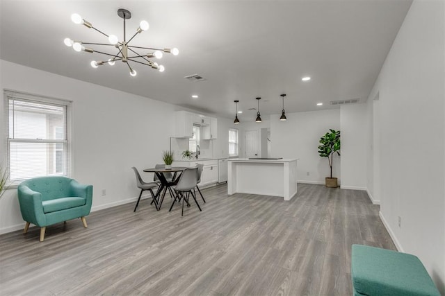 1617 NW 31st St, Oklahoma City, OK 73118 - kitchen featuring white cabinetry, decorative light fixtures, light hardwood / wood-style floors, and a center island