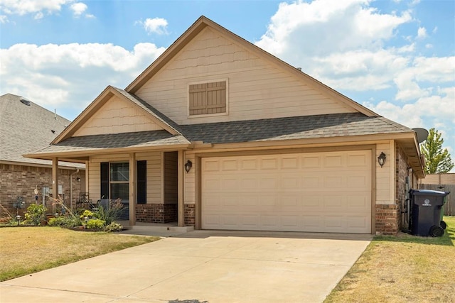 craftsman-style home featuring a garage, covered porch, and a front yard