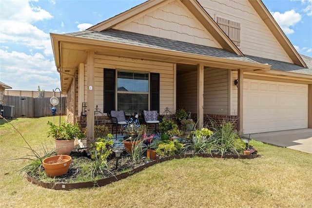 view of front of house with central AC, a garage, and a front lawn