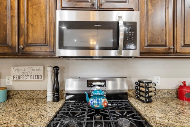 room details with light stone counters and appliances with stainless steel finishes