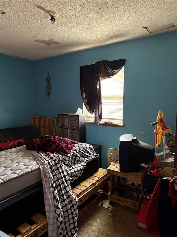 carpeted bedroom featuring a textured ceiling