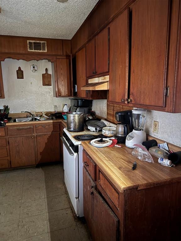 kitchen featuring butcher block countertops, sink, white electric stove, and a textured ceiling