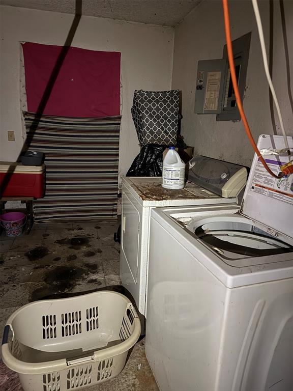 clothes washing area featuring electric panel and washer and clothes dryer