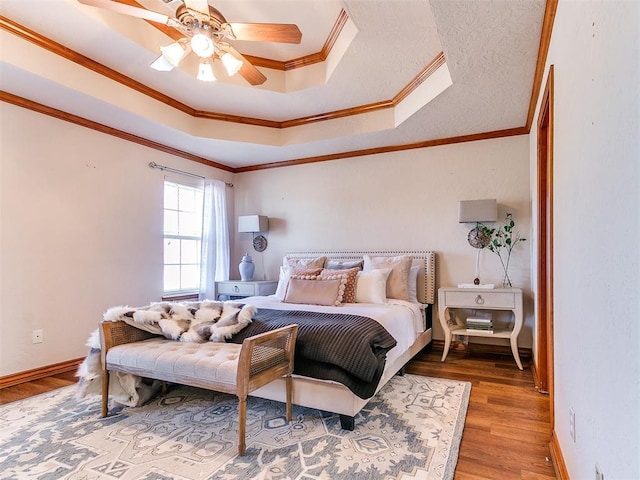 2508 Hamden Ave, Norman, OK 73069 - bedroom with a ceiling fan, wood finished floors, baseboards, ornamental molding, and a tray ceiling